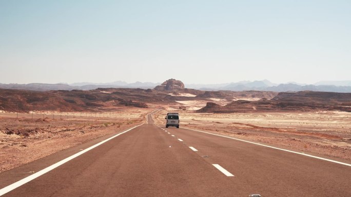 小巴驶过空旷的柏油路，驶进远方荒蛮的沙漠。在炎热的天气自驾游
