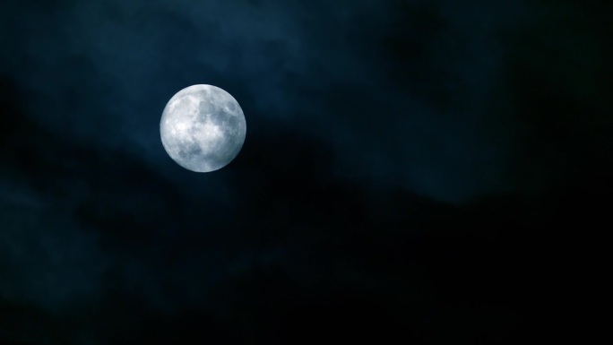 蓝冷的满月在多云的夜空