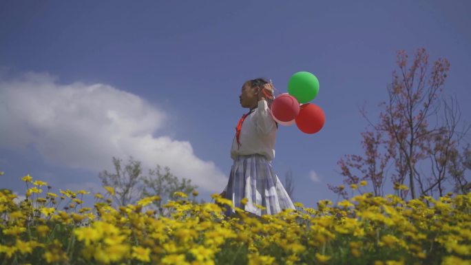 小学生拿气球 花丛中
