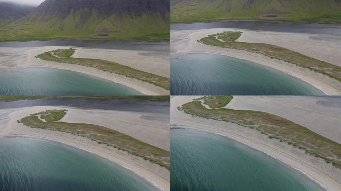 在多云的日子里，冰岛岛上的白色沙礁与背景中的绿色山丘的空中接近镜头-倾斜向下运动