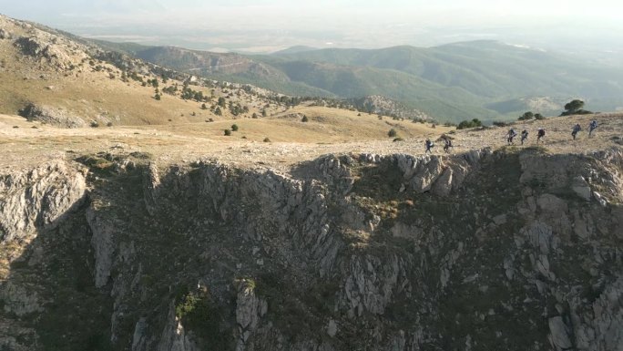 鸟瞰图:登山队一边在山上行走，一边欣赏森林和山顶的美景。