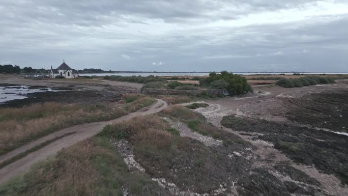 法国布列塔尼莫尔比汉湾的潘文斯海岸和Notre-Dame-de-la-Côte教堂。空中向前和天空为