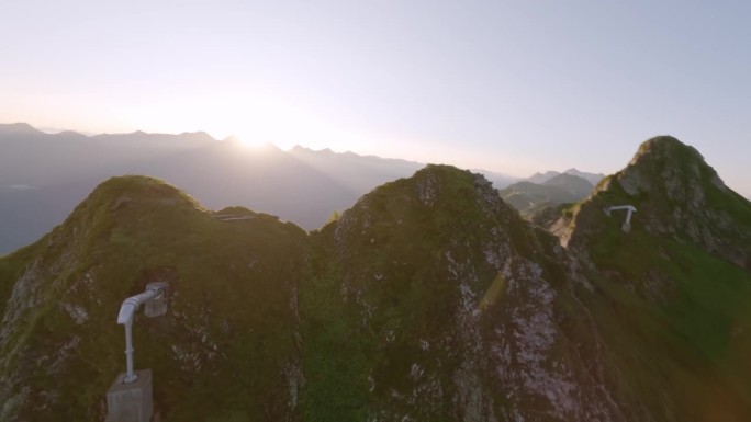 鸟瞰阳光明媚的山脉山谷，奔跑的高山山羊，野生动物和明亮的阳光