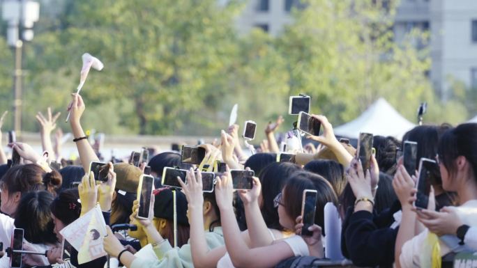 演唱会音乐节前排的歌迷观众拿着手机录视频