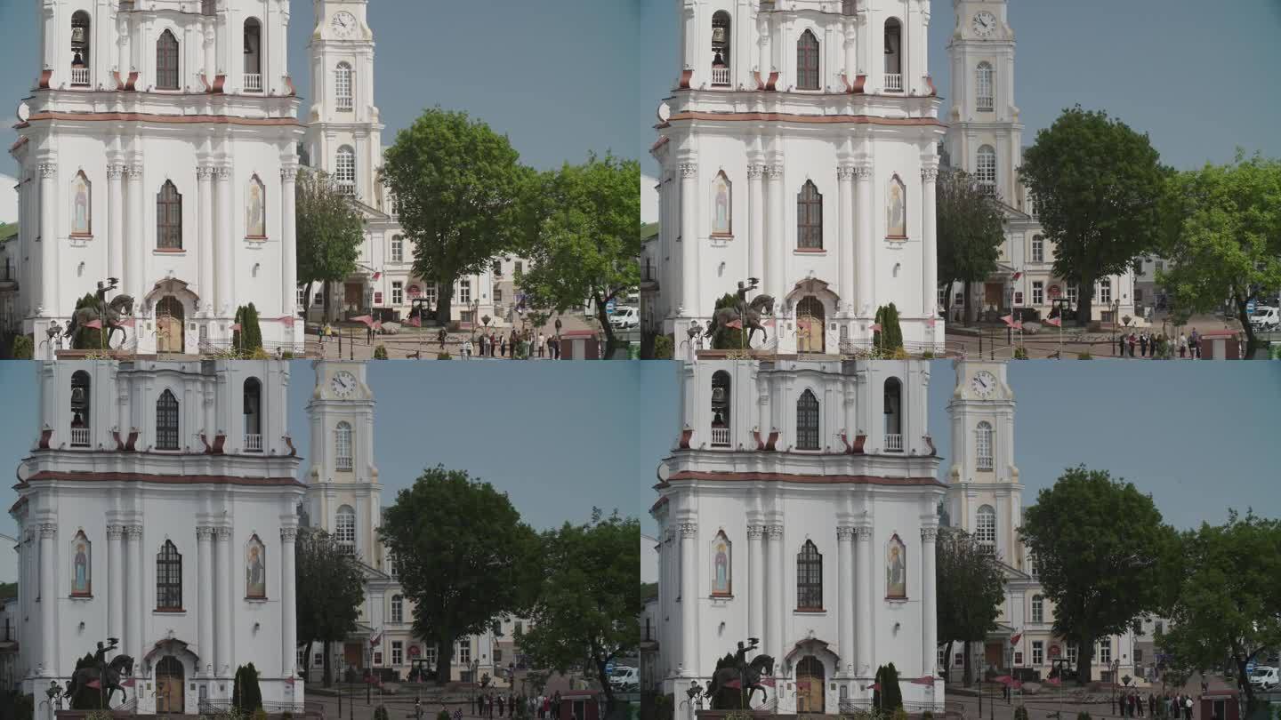 维捷布斯克,白俄罗斯。圣复活教堂。热门旅游目的地。手持猎鹰的游客靠近阿尔吉达斯纪念碑。间隔拍摄。维捷