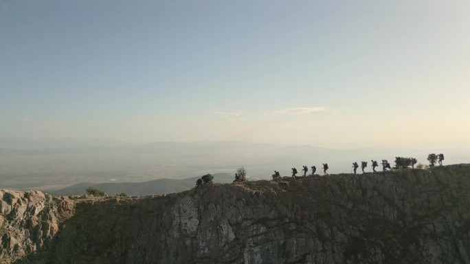 鸟瞰图:登山队一边在山上行走，一边欣赏森林和山顶的美景。