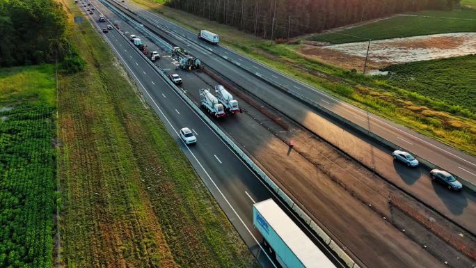 北卡罗来纳州高速公路中央车道上的混凝土搅拌机。道路两旁是秋天的田野。航拍镜头与平移相机运动