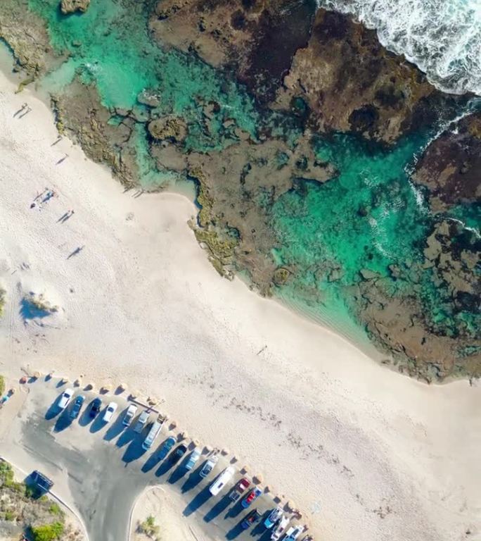 在一个阳光明媚的日子里，澳大利亚卡尔巴里的蓝洞海滩上停着汽车