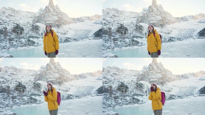 冬天，一名妇女在白云石的冰冻湖附近徒步旅行