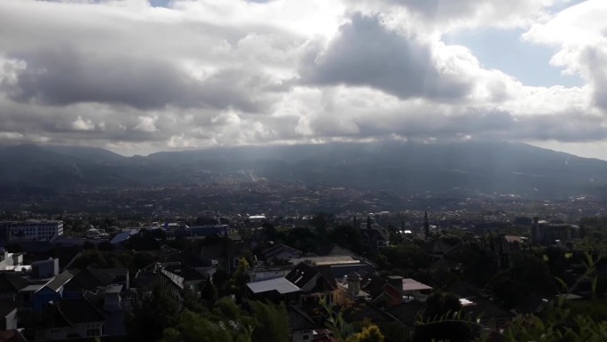 山景秀丽，山脚下有住宅。东爪哇玛琅的一个小山腰小镇。白云密布的山景