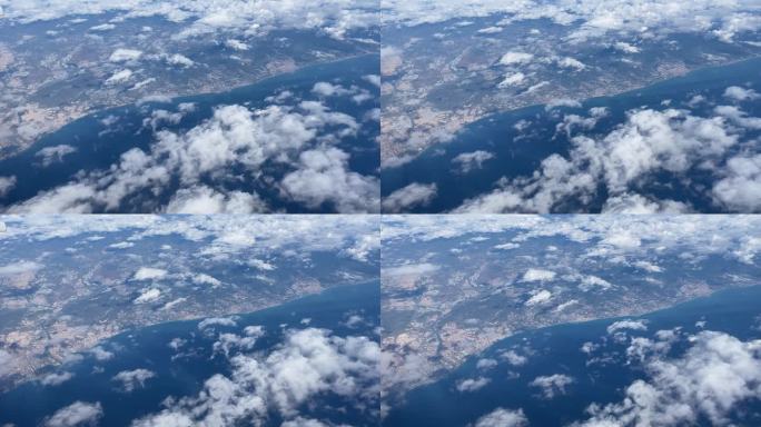 从飞机窗口俯瞰云层上方的蓝天。从上面看门户陆地。