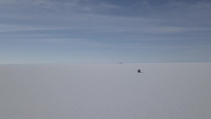 无人机拍摄的一辆4x4越野车行驶在乌尤尼盐湖周围的鱼岛，在玻利维亚安第斯山脉高海拔地区世界上最大的盐