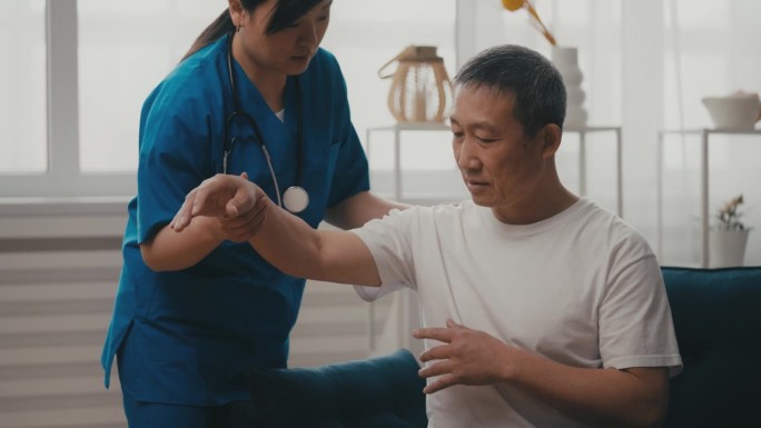 亚洲女医生在检查中检查老年男子手臂的恢复情况