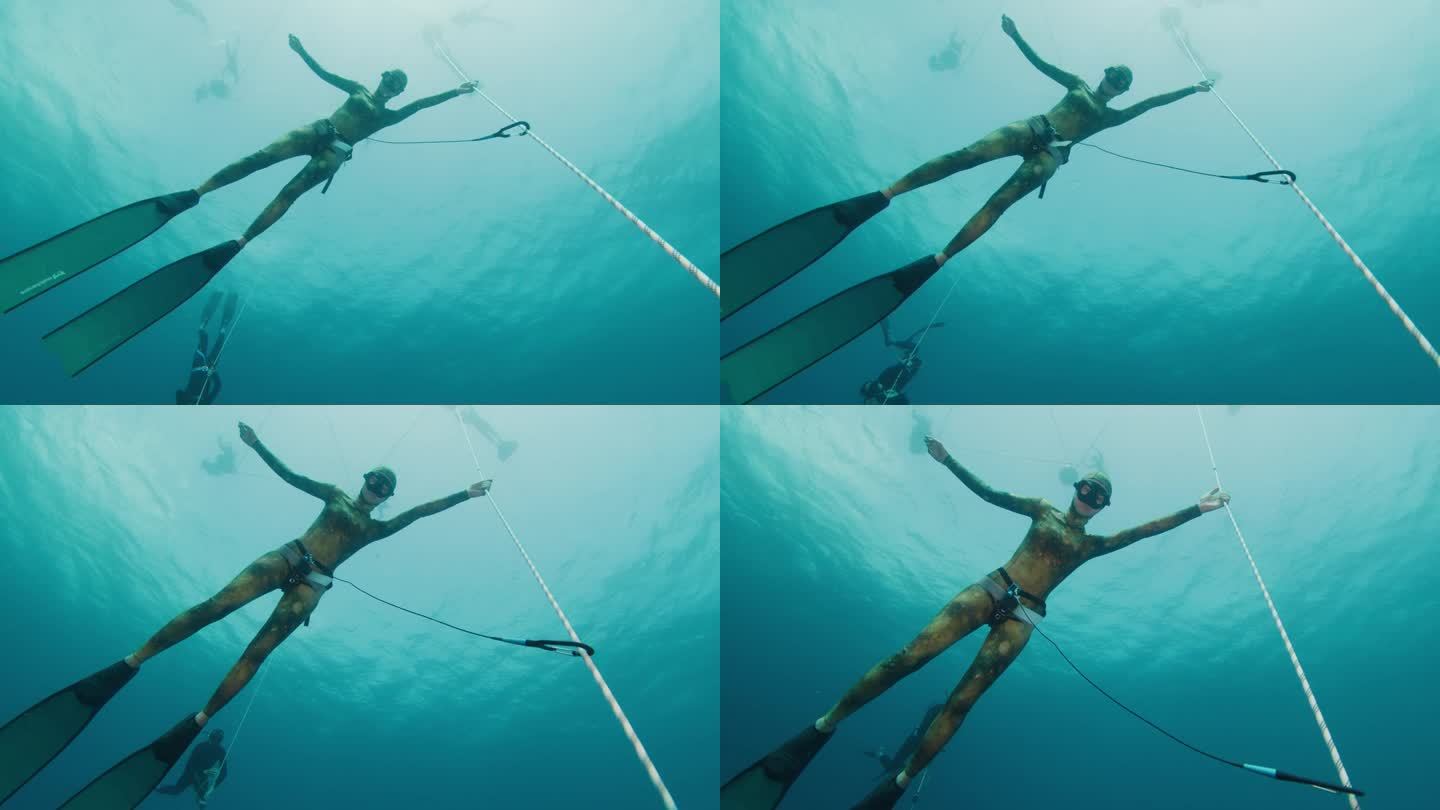 在海上的绳索上自由潜水。女自由跳水运动员在热身潜水时挂在绳子上，训练静态屏气