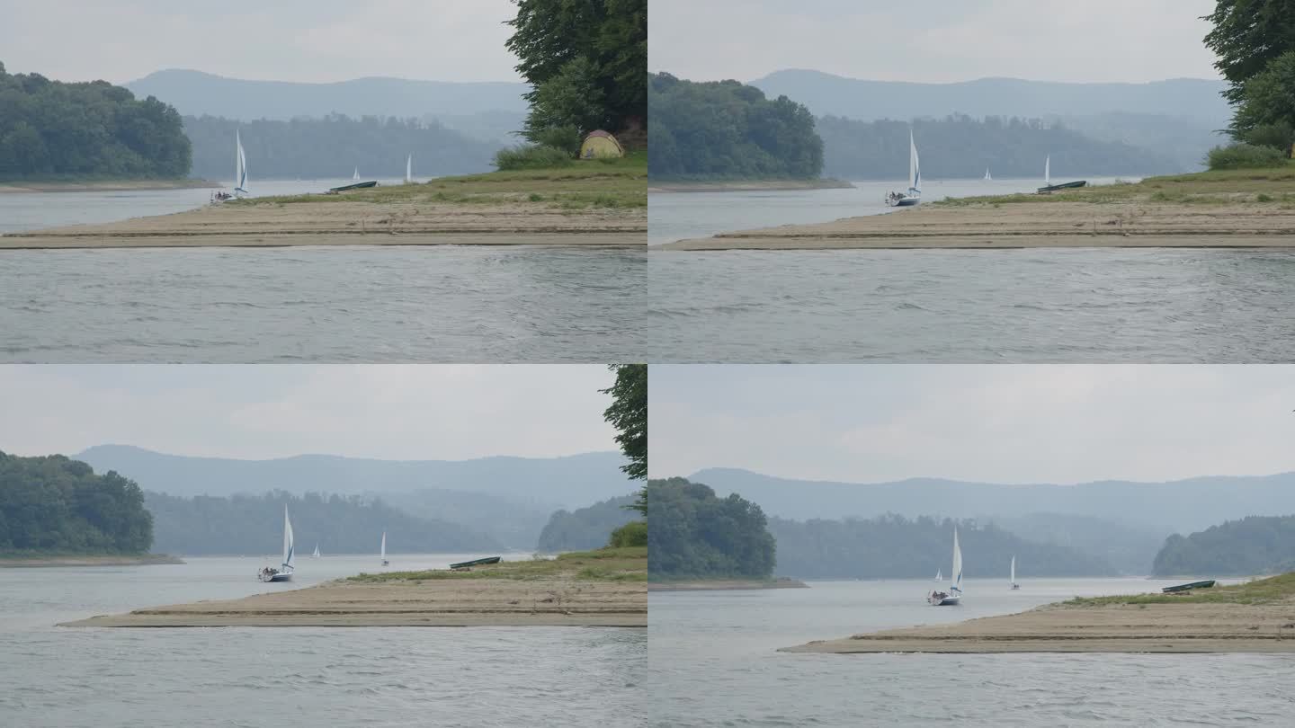 暑假在湖边。帆船在水面上划桨