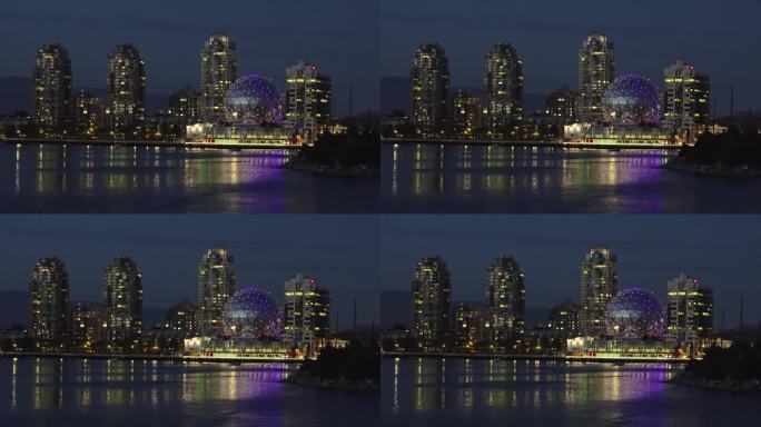 温哥华市的海岸线，夜晚地平线上的摩天大楼。科学世界大楼的灯光装饰