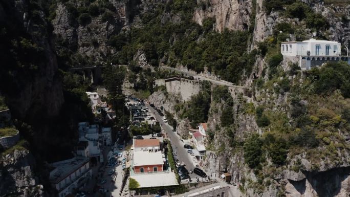 无人机穿过意大利陡峭山脉的照片显示，房屋建在陡峭的斜坡上。