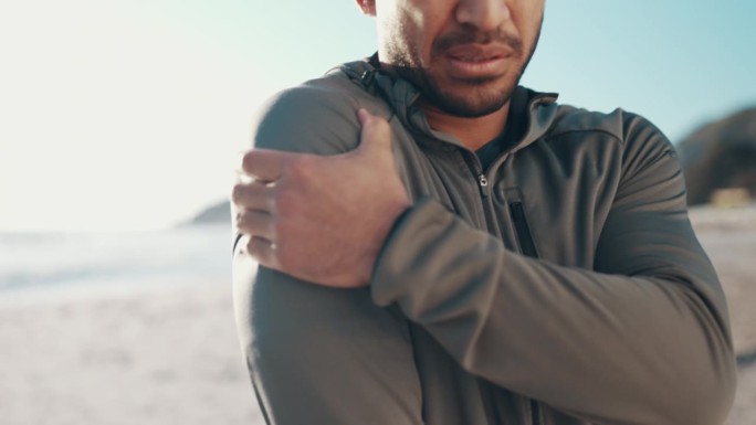 有健康风险的跑步者肩伤、沙滩和手、运动伤口或紧急户外。健身者、海洋、手臂肌肉关节痛、急救或运动意外的