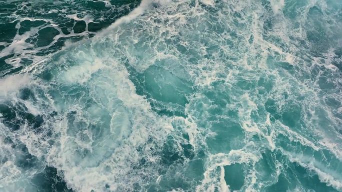 空中俯瞰的海洋风暴海浪。大海的海浪与白色的泡沫和蓝色的水。慢镜头，4K