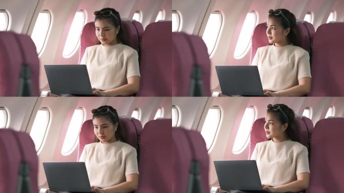 旅游和科技。坐头等舱。年轻漂亮的女商人坐在飞机上用笔记本电脑工作