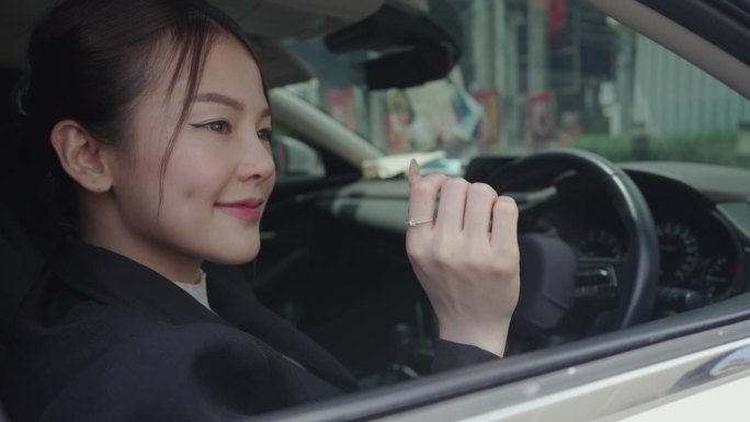 亚洲年轻漂亮的女商人购买或租赁汽车，收到车钥匙并在数字平板电脑上签字。