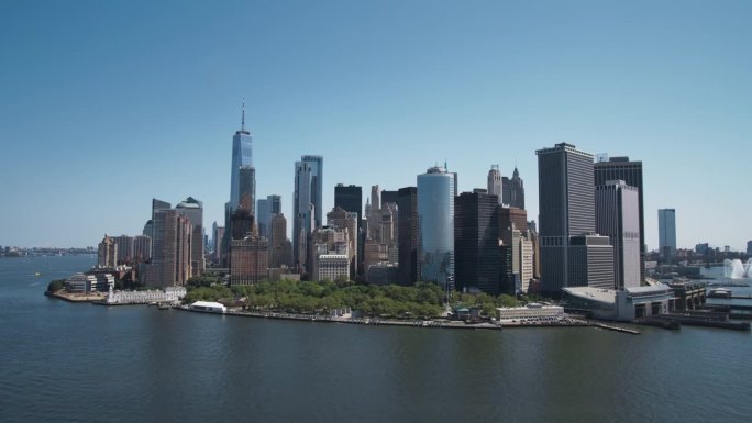 航拍镜头的摄像机接近曼哈顿岛的办公室和公寓大楼。哈德逊河风景与游艇，船只，一个世界贸易中心摩天大楼在