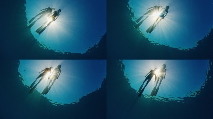 两名女子自由潜水者在水面上放松。在阳光明媚、风平浪静的日子里，女性浮潜在海面上的水下景象