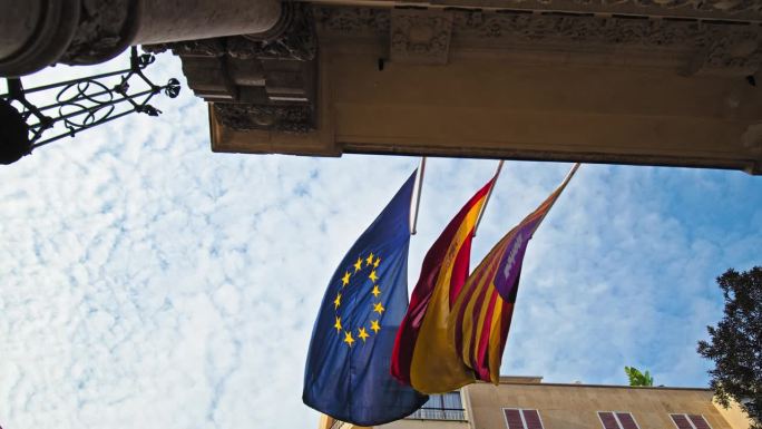马略卡岛的一座建筑上飘扬着欧洲、西班牙和加泰罗尼亚的旗帜。