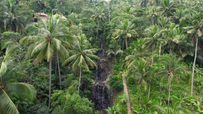 在印度尼西亚巴厘岛的热带丛林中，人们在小瀑布瀑布的无限风格的岩石池中沐浴，在Sidemen村空中接近
