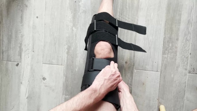 膝关节支架与患者腿部的特写，背景为复制空间