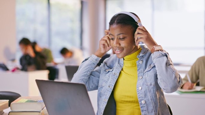 耳机，电脑和黑人妇女在课堂上听音乐，播放列表或专辑在大学。科技、笔记本电脑和非洲学生在大学里做流媒体