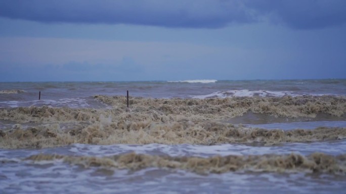 海滩上波涛汹涌，海水浑浊。