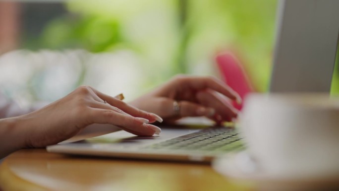 女商人在笔记本电脑键盘上打字，并使用触摸板，手的特写视图