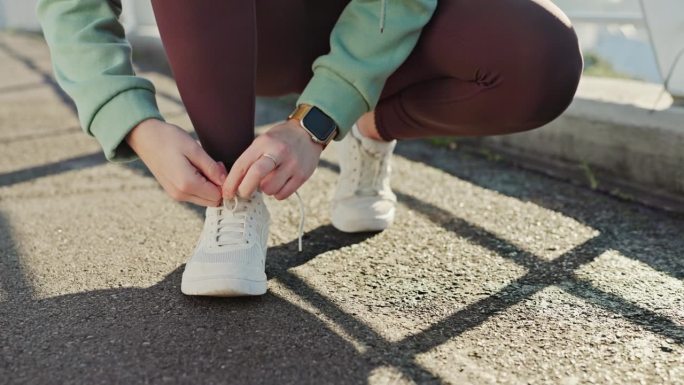 女士，适合跑步、训练或在柏油路、道路或桥梁上进行户外运动。女性的特写，跑步者或运动员和手系鞋带准备有