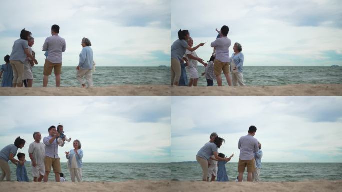 几代同堂的一家人站在沙滩上看美丽的大海。