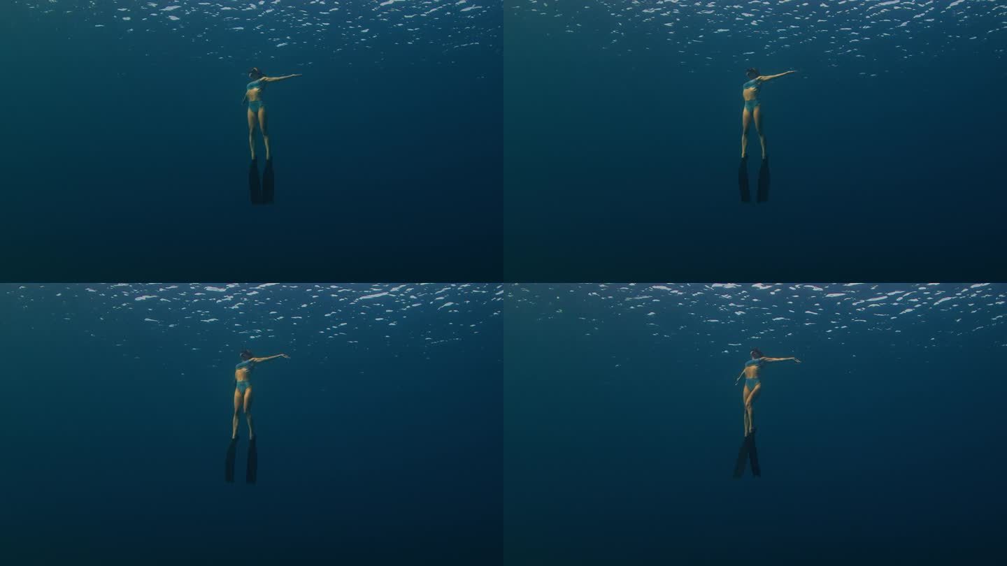 日落时分，女自由潜水员在水下游泳，慢慢地接近水面