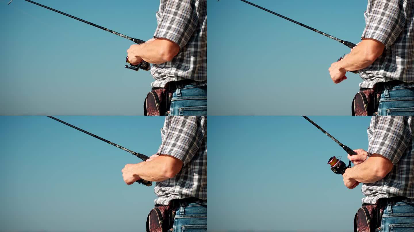 一个成年男子用纺丝竿钓鱼的手特写。