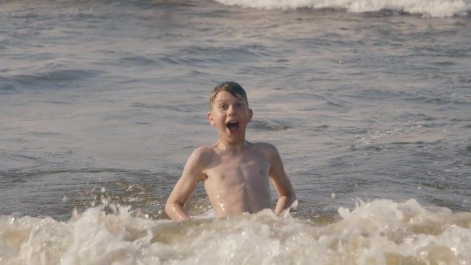 男孩在海里玩耍外国人海边游泳视频素材