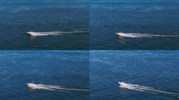 航拍放大图，一艘白色的船驶向蓝色的大海。高速移动的。慢动作