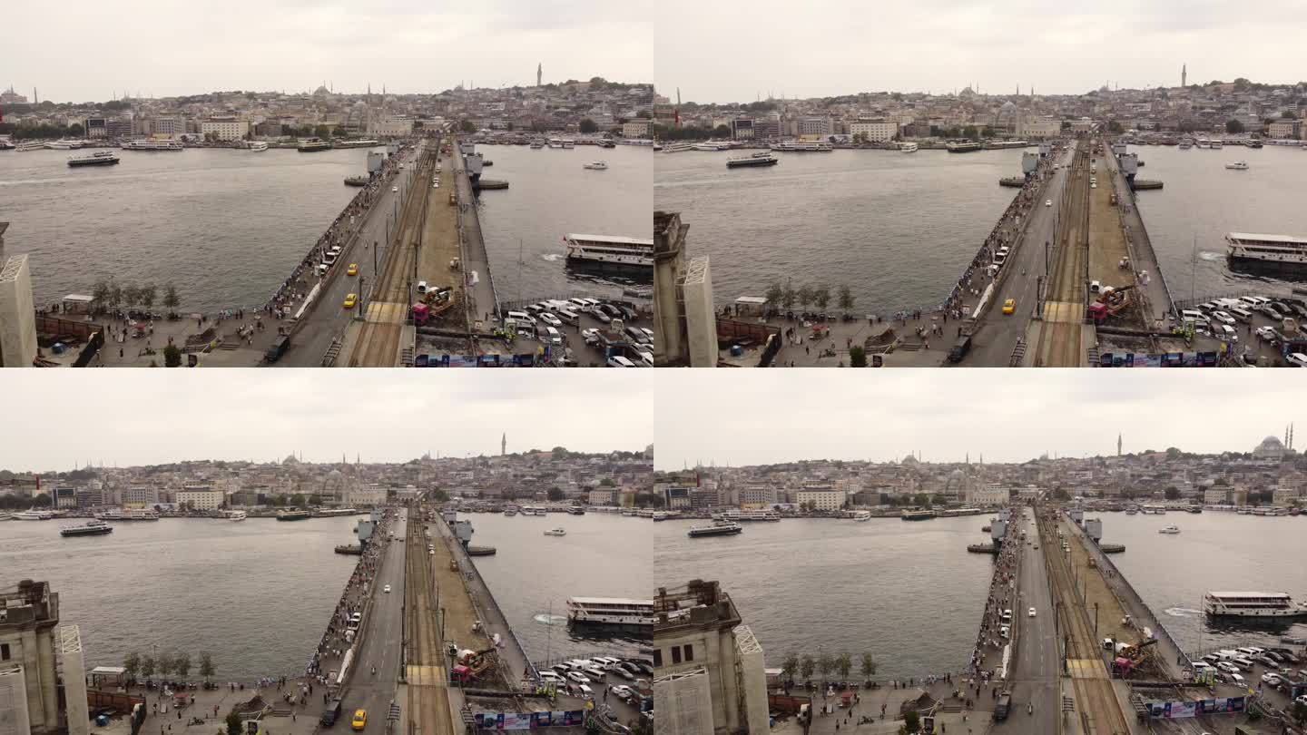 空中无人机拍摄的伊斯坦布尔加拉塔大桥的画面，大桥上悬挂着土耳其国旗，博斯普鲁斯海峡和船只经过