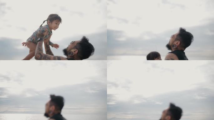 亚洲父亲抱着他的小儿子围成一圈，在美丽的天空的海滩上，他们在一个美丽的日子里尽情地笑。