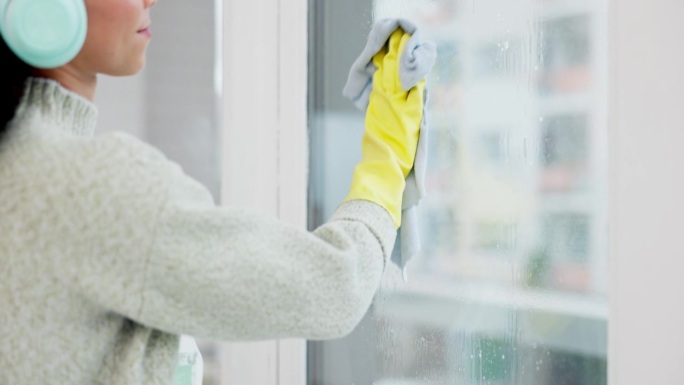 为了卫生、保护或消毒，家庭客厅的耳机、窗户和女喷清洁玻璃门。污垢、灰尘和从事家庭或卫生家政工作的人或