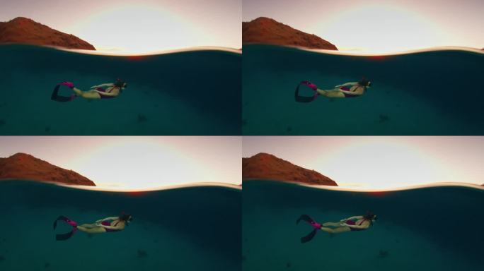 日落时分在热带海洋中游泳的女子的电影胶片。冻结的海面框架和移动的水下模型