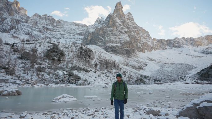冬天，一名男子在白云石的冰冻湖附近徒步旅行