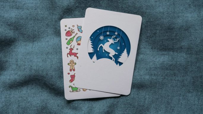 蓝色的彩色剪纸风格驯鹿和圣诞快乐的文字动画垂直圣诞贺卡
