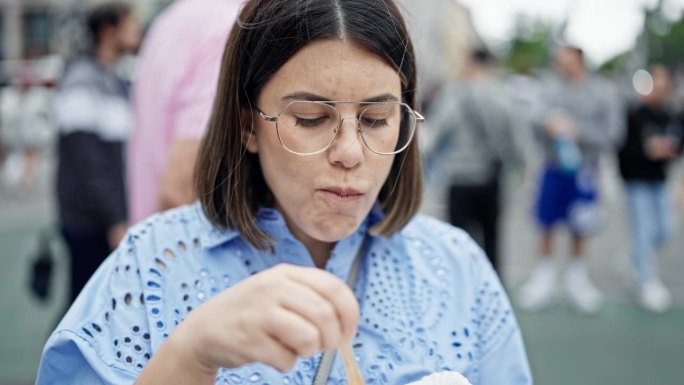 年轻美丽的西班牙女子在维也纳街头吃Käsekrainer香肠