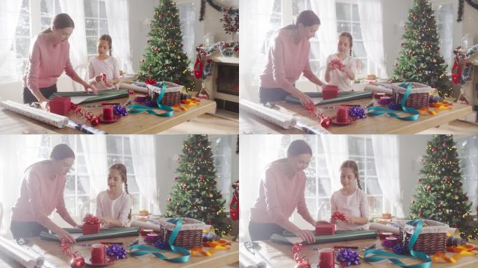 母亲和女儿在家里包装圣诞礼物的慢动作肖像。可爱的小女孩为送给家人的礼品盒挑选装饰品。充满爱和分享的节