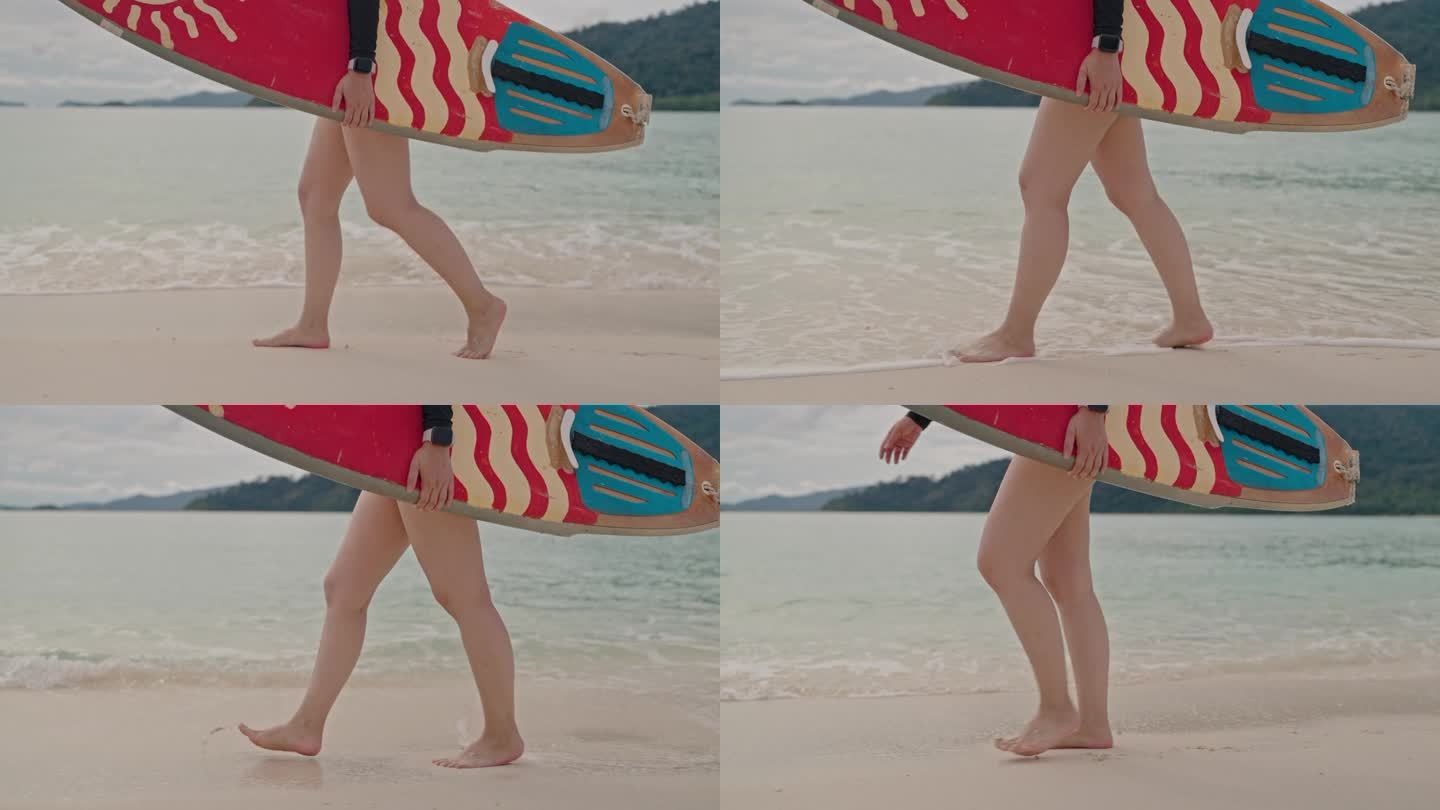 女子手持冲浪板在沙滩上行走的特写镜头