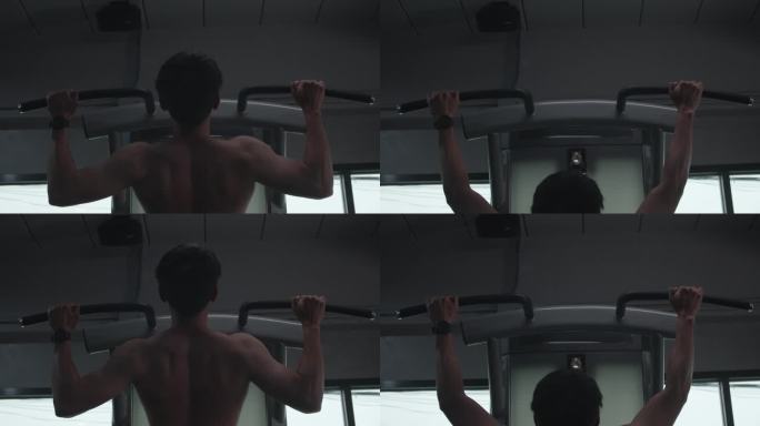 亚洲健身男子引体向上与杆辅助引体向上机器