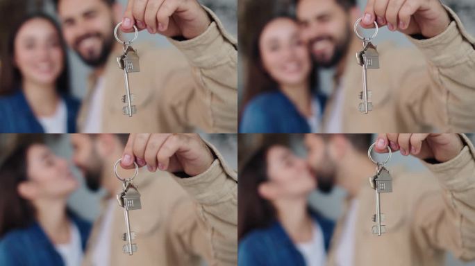 一对恩爱的夫妇站在厨房的圣诞树旁，展示着他们新家的钥匙。快乐的新婚夫妇纪念第一套房子的购买，珍惜的新